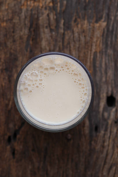 Soy milk with soybeans on wood background