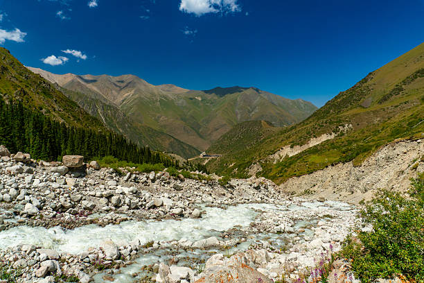 istock Ala-Archa Mountain adventure destination featuring alpine camp, fast flowing river, rugged rocks, lush forest, steep slopes, and panoramic mountain views. Trekking, hiking, climbing, and exploration 2228937781