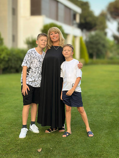 Young Mother overwhelmed with home life as two little boys have a sword fight around her