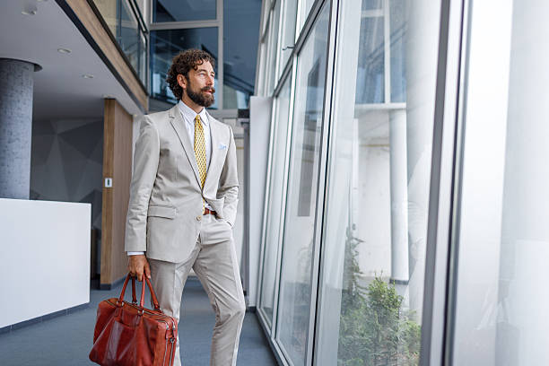 istock Businessman looking out the window in modern office building 2228939979