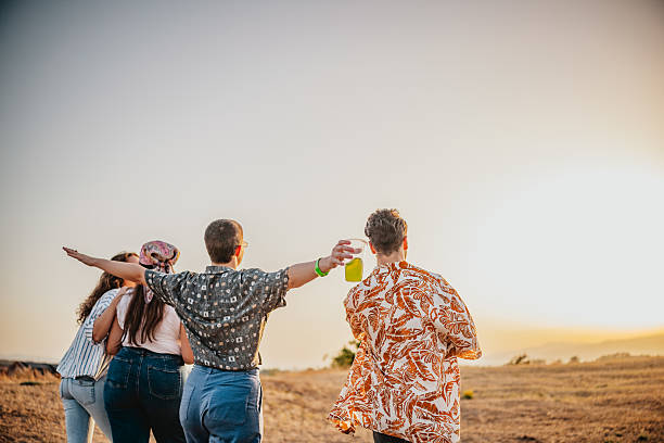 Group of friends captured against a glowing sky in a peaceful, open field