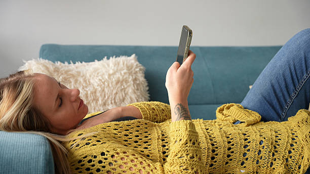 istock Woman Relaxing on the Sofa Using her Smartphone 2228942073