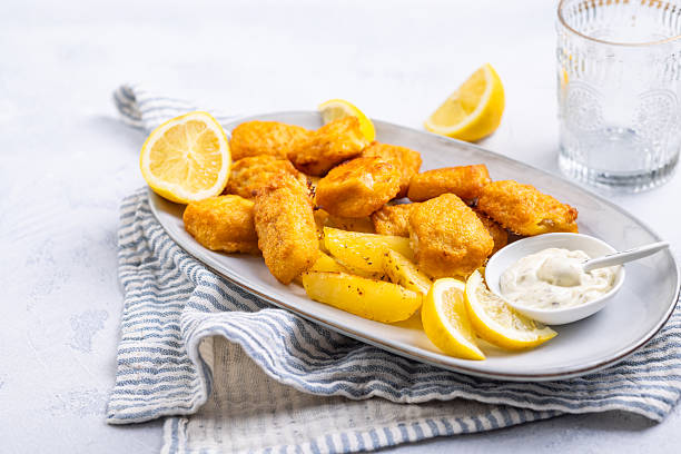 Traditional fish and chips with lemon and tartar sauce on serving plate