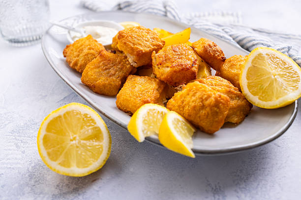 Traditional fish and chips with lemon and tartar sauce on serving plate