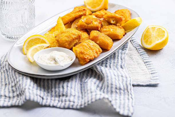 istock Traditional fish and chips with lemon and tartar sauce on serving plate 2228942865