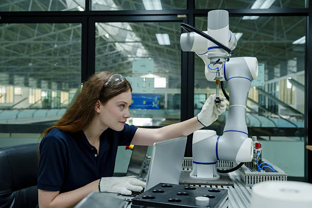 istock caucasian engineer woman interacting with robotic arm during real world training for automation and robotics in smart factory environment developing industry 4.0 workforce skills 2228944964