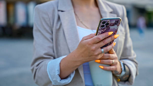 Businesswoman Using Smartphone Outdoors,Checking Messages and Emails