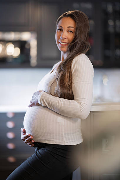 istock Smiling pregnant woman standing confidently in a modern kitchen environment 2228962578