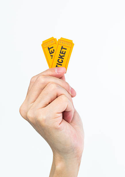 istock Hand holding two yellow cinema tickets on white background 2228962793
