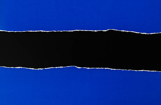 istock Torn blue paper revealing black background 2228963097
