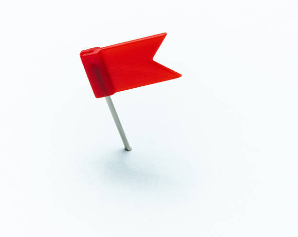 istock Red flag shaped pushpin isolated on white background 2228963299
