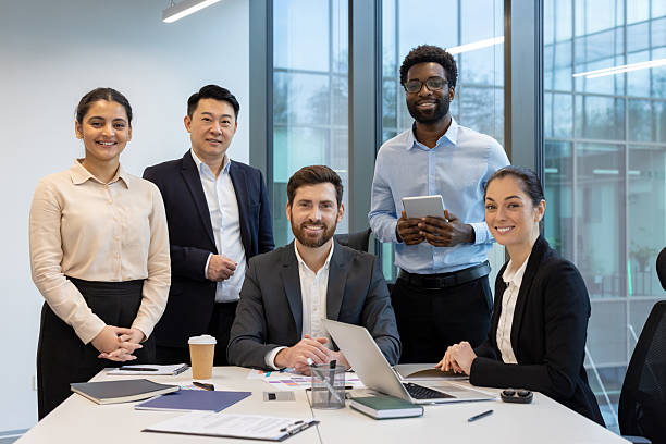 istock A diverse group of professionals standing in front of a table smiling for the camera. 2228972250