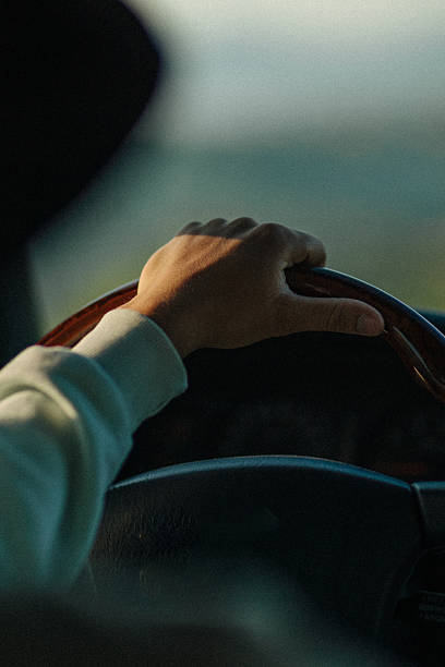 istock View past hands on vehicle wheel through vehicle window 2228974230