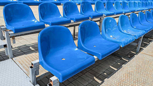 istock Rows of empty blue stadium seats on metal frame under bright sunlight. Ideal for sports, event and spectator themes 2228974554