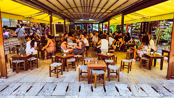 Daily life in a traditional Turkish bazaar during summer, Turkish flags are visible, with local shops, street food vendors, and tourists exploring the market in Konak, Izmir, Turkey on August 06, 2025