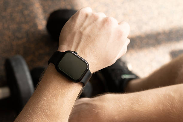 istock Hand with smartwatch set against background at gym. 2228979452