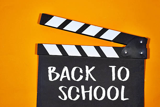 istock Back to School Text on a Film Slate Board with Orange Background 2228979808