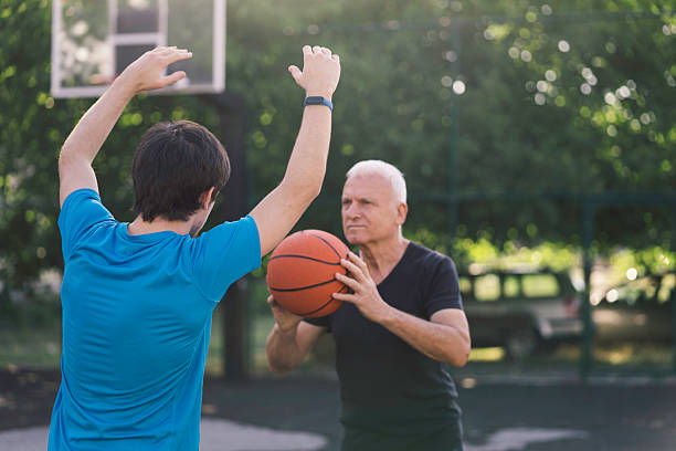 istock Active seniors playing basketball outdoors together 2228980308