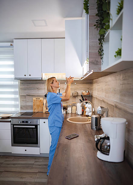 istock Female Doctor Opening Kitchen Cabinet at Home After Work 2228981224