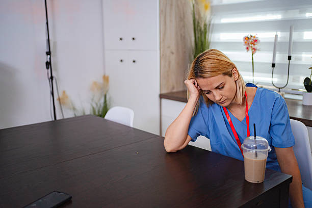 istock Exhausted nurse resting her head on a table during a break 2228981270