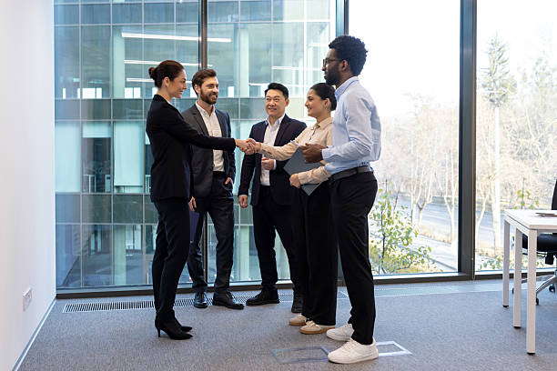 istock Professional team handshake in a modern office with large glass windows 2228981500