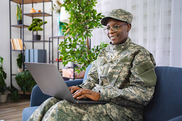 istock Smiling female soldier using laptop at home 2228981831