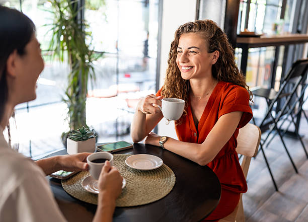 istock Two young women talking and drinking coffee in a cafe 2228983449