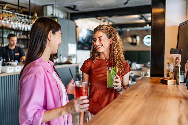 istock Two young women enjoying drinks and conversation at a bar 2228984560