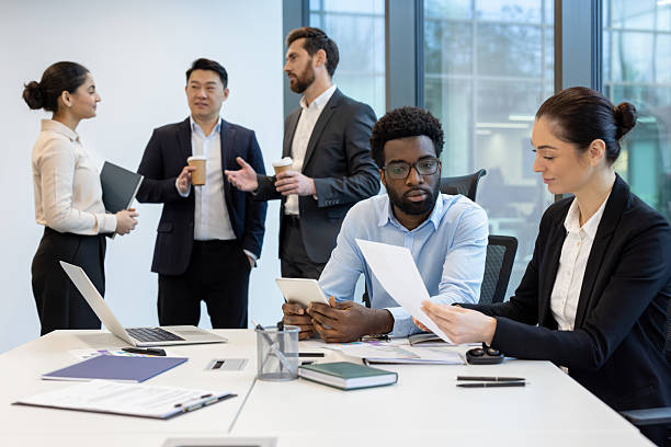 Business professionals review documents during a collaborative office meeting.