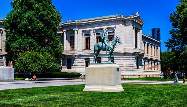 Boston, Massachusetts, USA - August 2, 2025: The Museum of Fine Arts (often abbreviated as MFA Boston or MFA) is an art museum in Boston, Massachusetts. It is the 20th-largest art museum in the world, measured by public gallery area. It contains 8,161 paintings and more than 450,000 works of art, making it one of the most comprehensive collections in the Americas. Founded in 1870 in Copley Square, the museum moved to its current Fenway location in 1909. In front of the Museum of Fine Arts building is the Appeal to the Great Spirit, a 1908 equestrian statue by Cyrus Dallin. It portrays a Native American on horseback facing skyward, his arms spread wide in a spiritual request to the Great Spirit.