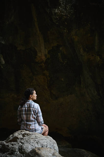 Person Sitting in a Cave Setting Contemplating and Observing the Natural Environment