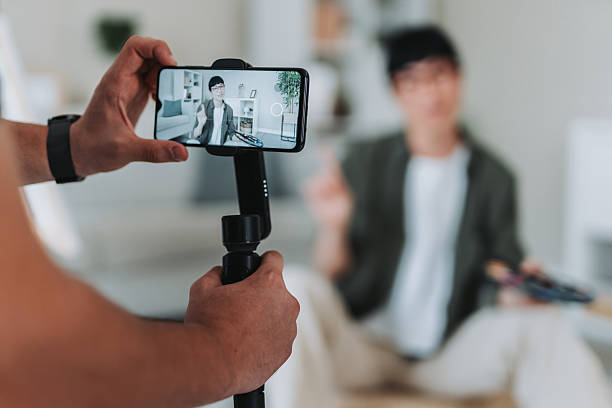 istock Man recording influence creating content with smart phone gimbals 2228993032