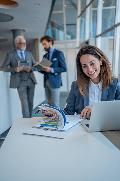 istock Businesswoman analyzing charts and working on laptop in modern office 2228993619
