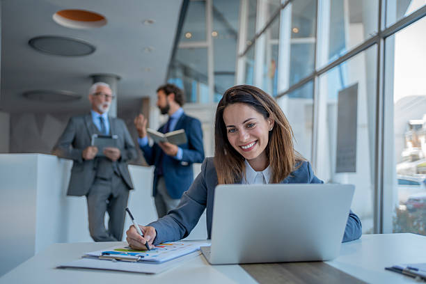 istock Smiling businesswoman working on laptop in modern office 2228993632