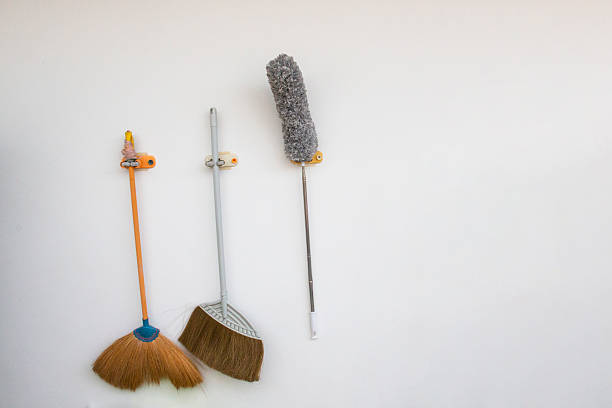 Three brooms leaning against the wall