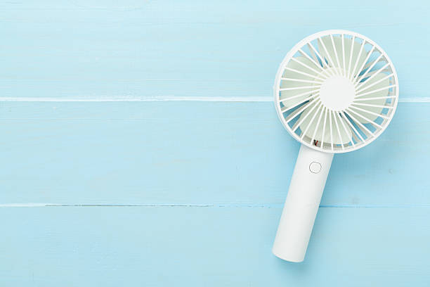 istock Mini electric fan on wooden background, top view 2228995435