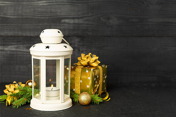 Beige christmas lantern with decorations on wooden table