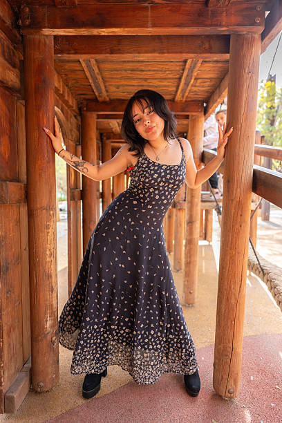 istock Young woman posing in a long dress inside a playground structure 2228997339