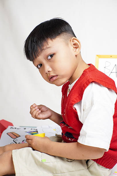 istock Smiling boy holding a lemon in a playful school setting 2228998503