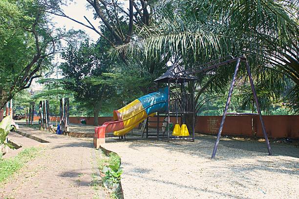 istock Empty Playground Slide Surrounded by Greenery. Peaceful Park Playground with Colorful Slide 2228999709