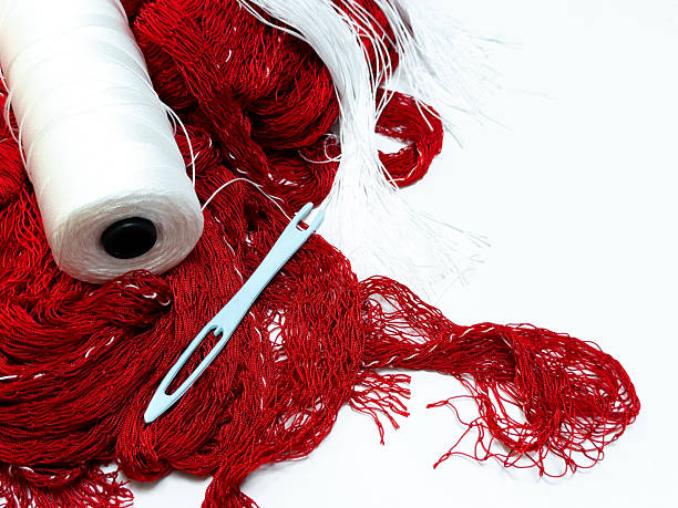 Red and white yarn with needle on white background for crafting and knitting projects