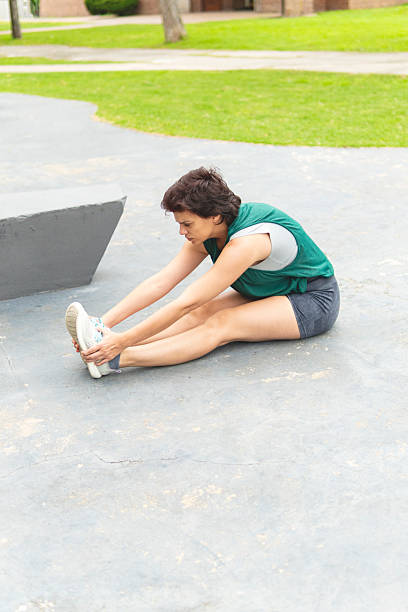 istock Woman doing stretching exercises in a public park 2229005163