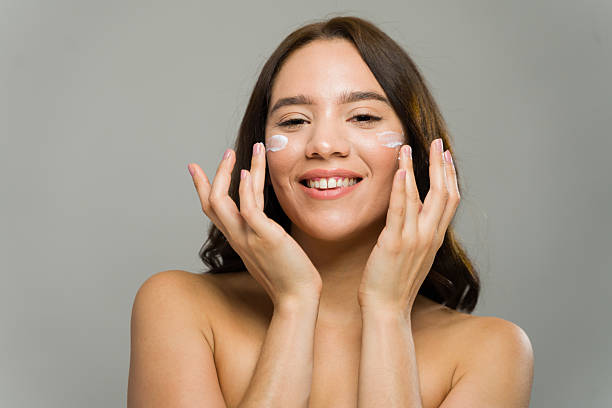 istock Young woman applying moisturizer cream for skincare routine 2229007004