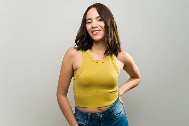 istock Young woman smiling and posing in studio with hand on hip 2229008893