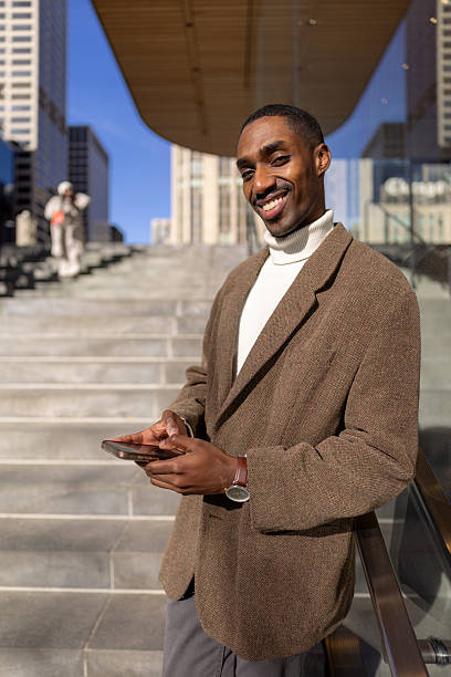istock Young businessman using smartphone and smiling in the city 2229010483