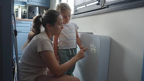 istock Smart Home. Mother & Child Turn On Home Heating Or Cooling System 2229010667