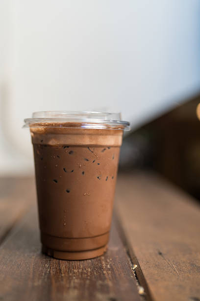 A glass with iced chocolate milk on transparent cup glass