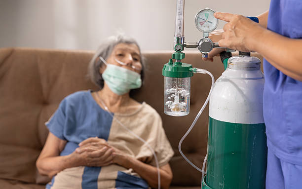 Elderly woman wearing oxygen nasal cannula at home.