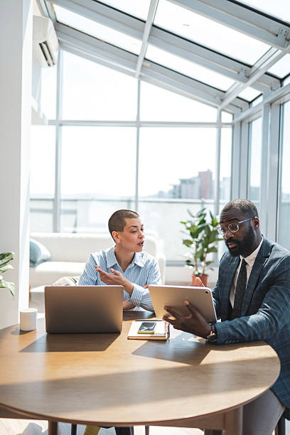 istock Two business professionals collaborate in a modern office setting with natural light 2229013780