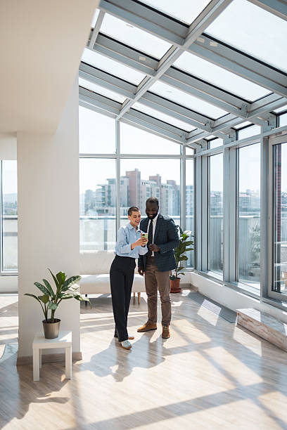 istock Professional colleagues in a bright, modern office discussing work on a mobile device 2229013798